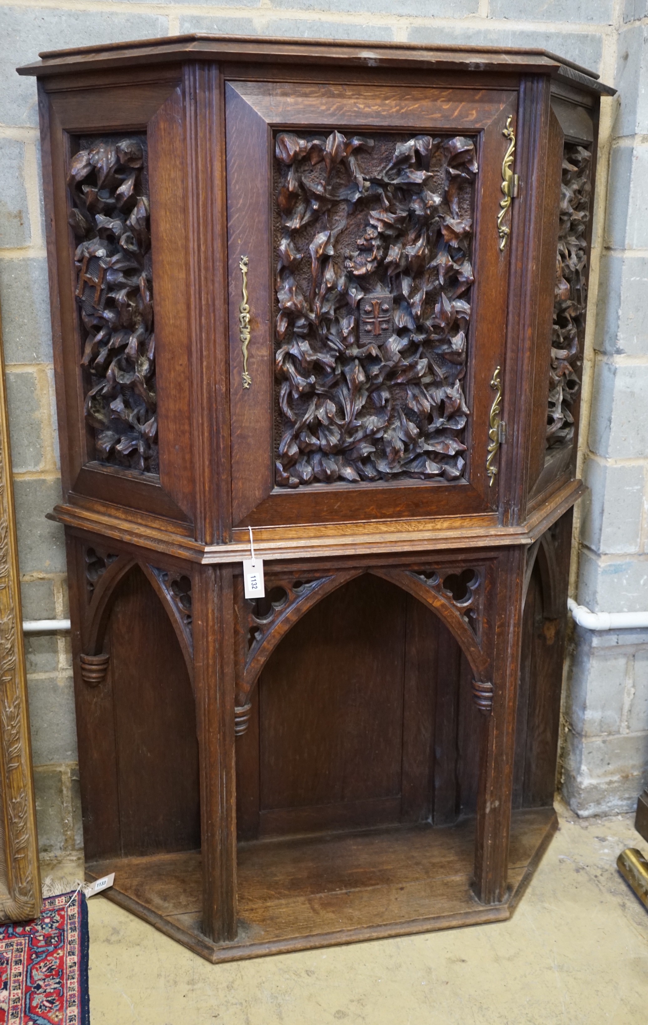 An early 20th century Gothic style carved oak side cabinet, width 118cm, depth 36cm, height 176cm